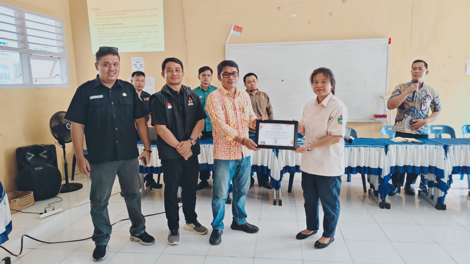 Foto: Penyerahan Piagam oleh Kordiv HP2H (Yosua Buulolo) kepada Guru SMK Negeri 2 Dharma Caraka Teluk Dalam atas Pelaksanaan Kegiatan Sosialisasi Pemilih Pemula, (Kamis, 20/11/2025).
